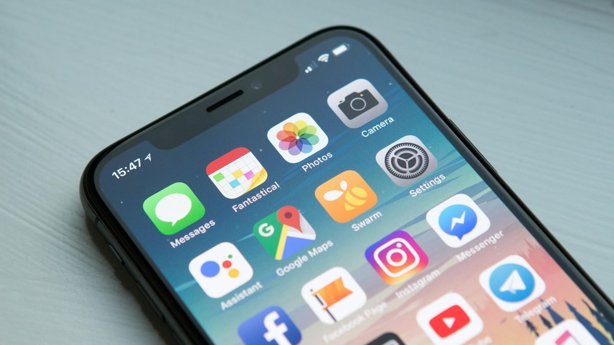 Smartphone home screen on a light desk, angled close-up